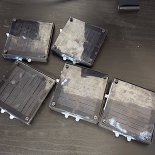 Four solar light cases on a dark bench