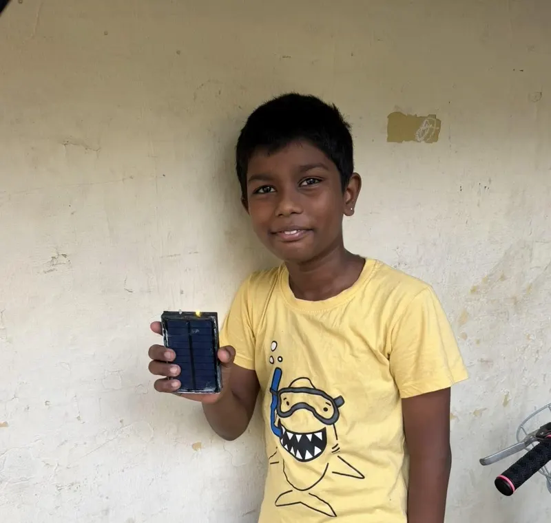 A student in India holding a Flash Forward solar study light