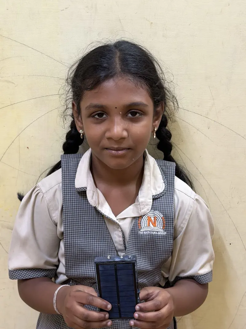 A student in India holding a Flash Forward solar study light